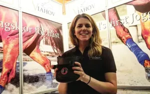 Bild på Anna Hane som håller en joggingsko till häst